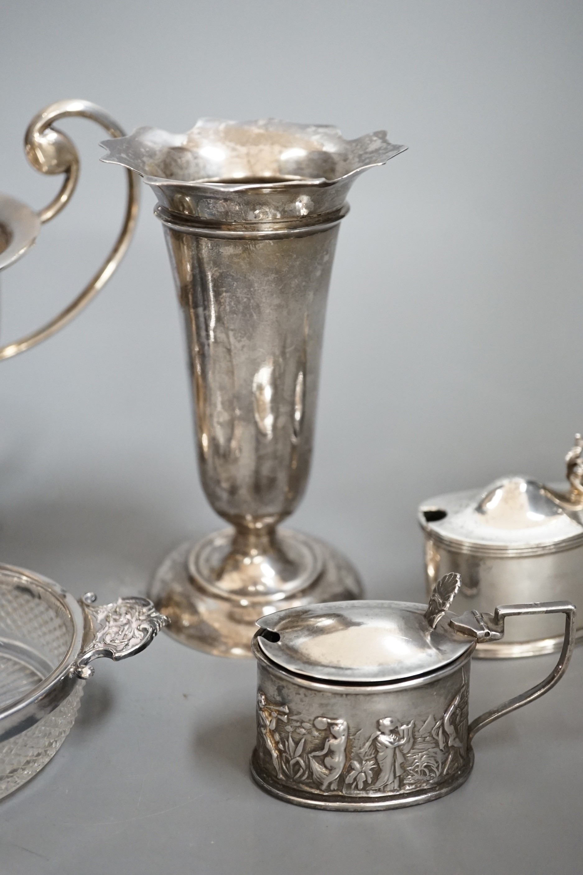 A group of assorted small silver items to include a posy vase, silver-mounted cut glass quaich, a twin-handled silver cup and three condiments.